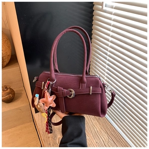 Macro view of vintage wine red pillow bag featuring silver hardware and a star pendant