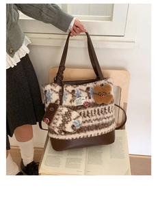 Detail of Nordic knit tote bag with brown leather handles and cute bear charm