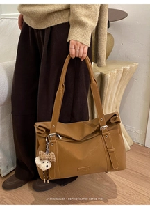 Détail du sac cabas rétro marron avec breloque chiot en peluche et fermeture à rabat