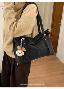 Détail du grand sac cabas noir avec sangles latérales et breloque chien en peluche