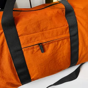 Detail of the smooth black zipper on the water-resistant orange travel bag fabric