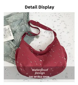 Close-up of waterproof nylon material showing water resistance on a burgundy crescent bag