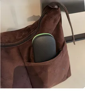 Detail view of the brown suede tote side pocket showing functional storage capacity
