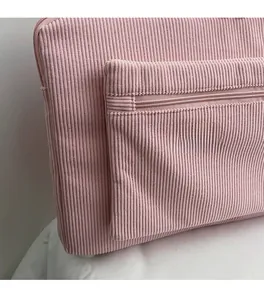 Detailed close-up of pink corduroy fabric texture and front zipper pocket on laptop bag