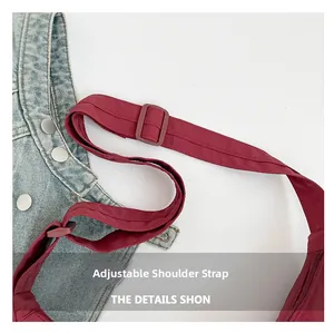 Detailed macro view of adjustable red shoulder strap with matching buckle on canvas tote