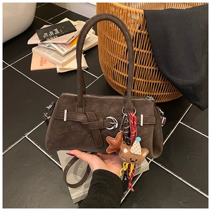 Close-up of vintage brown matte tote bag with star and cartoon bear charms decoration