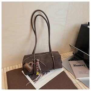 Detail of dark brown suede shoulder bag with heart charm and colorful chain accessories