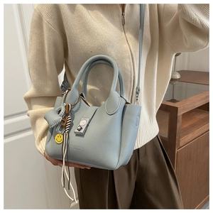 Detalle del bolso de cuero azul claro con cierre de metal de reloj y correa ajustable