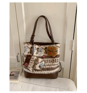 Detail of wool tote bag with teddy bear charm and soft textured winter fabric