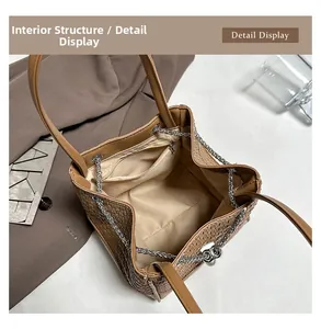 Detail view of woven brown tote bag featuring interior zipper pocket and metal chain drawstring
