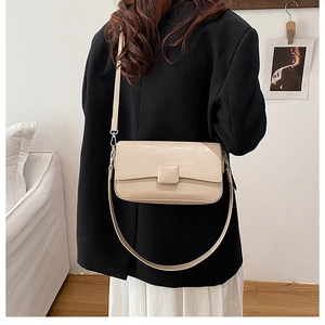 Minimalist beige crossbody bag styled with a black blazer for a chic daily look
