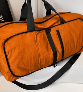 Detail of orange sports bag with durable nylon fabric texture and black woven handles