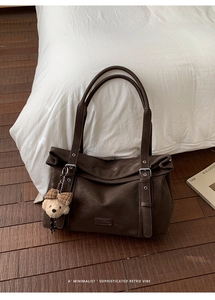 Détail du grand sac cabas en cuir vintage marron avec pendentif ours en peluche