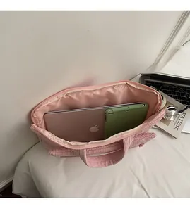 Detail view of pink corduroy tote bag showing spacious interior with laptop and tablet