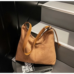 Detail of vintage brown suede tote bag with adjustable strap and front pockets