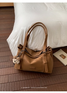 Détail du sac cabas marron mat avec étiquette Fashion et breloque ours à carreaux