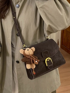 Bolso bandolera retro café oscuro con cierre en D dorado y amuleto de oso de punto