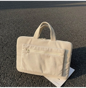 Détail du sac d'ordinateur en velours côtelé montrant la texture et la poche avant
