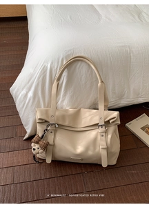 Détail d'un grand sac cabas beige avec boucles argentées et charme d'ours en peluche