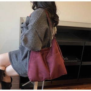 Deep burgundy faux suede hobo bag with side pocket and stitching detail shown on model