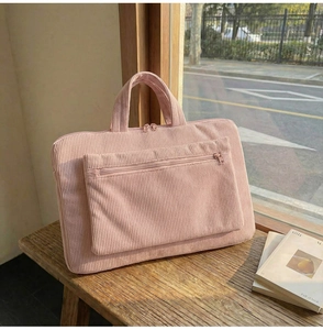 Détail de la texture d'un sac d'ordinateur en velours rose sur un rebord de fenêtre