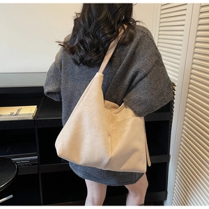 Detail of soft beige suede tote bag showing large capacity and smooth matte texture