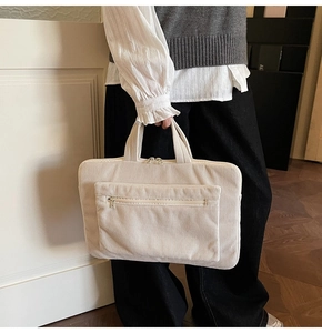 Detail of cream corduroy laptop tote bag with front zipper pocket and sturdy double handles