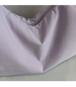 Close-up of soft lavender fabric texture and matching zipper on minimalist crossbody bag