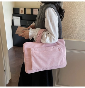 Detail view of pink corduroy tote bag showing the soft ribbed texture and front zipper pocket
