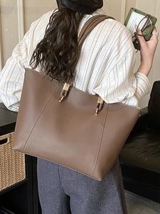 Large brown leather tote bag with gold ring hardware for casual daily commute