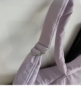Detail of light purple soft shoulder bag featuring silver metal rings and padded strap