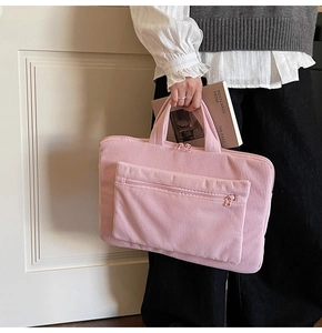 Macro view of pink corduroy laptop bag texture with a functional front zipper pocket