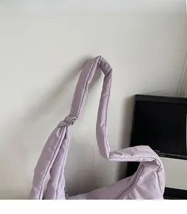 Detail of lavender puffy dumpling bag featuring soft padded shoulder strap and silver ring