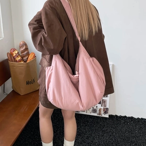 Detailed back view of a pink large capacity puffer shoulder bag in a home setting