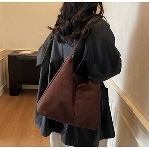 Detail of large brown suede tote bag featuring a practical side pocket and minimalist design