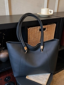 Large dark grey tote bag with gold ring hardware and structured panel design