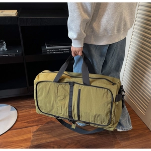 Olive green travel bag detail with reinforced handles and adjustable shoulder strap