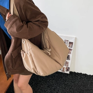 Macro detail of khaki crescent bag with drawstring pocket and smooth nylon texture
