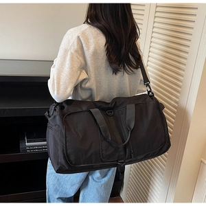 Close-up of black travel bag with adjustable strap and wide handles for gym or outdoor sport