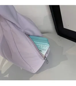 Detail shot of a lavender soft sling bag featuring a functional side zipper pocket