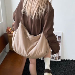 Detail of the large khaki crossbody bag featuring light waterproof fabric and drawstring