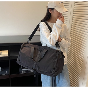 Black canvas gym bag with dry-wet separation and adjustable strap shown on model