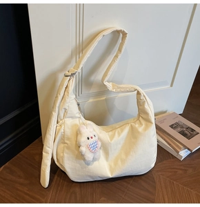 Cream white quilted hobo bag detail with a cute plush rabbit charm on a soft strap