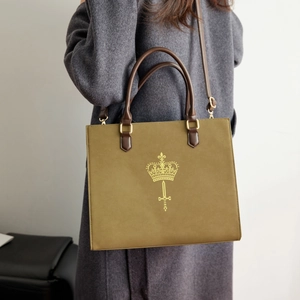 Detail of vintage olive green tote bag with gold crown print and leather strap