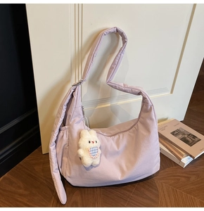 Detail of lavender quilted hobo bag featuring a cute white bunny plush pendant charm