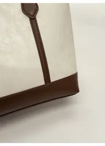 Détail d'un sac cabas en similicuir grainé avec coutures et panneaux contrastés