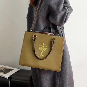 Detailed side view of an olive green leather tote bag with a golden crown emblem