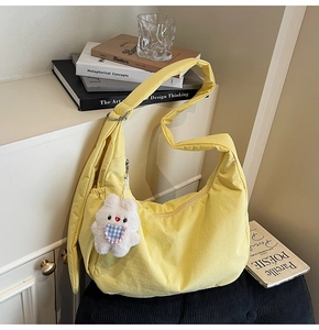 Detailed macro view of yellow hobo bag featuring a cute white plush bunny charm