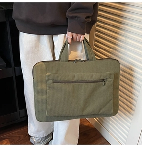 Détail du sac d'ordinateur en velours côtelé vert olive avec texture et poche zippée