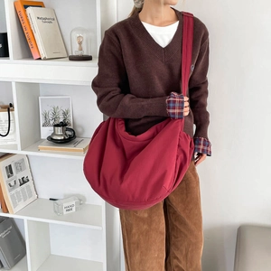 Deep burgundy crescent bag in high capacity nylon shown on a model with a retro outfit